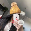 Zimowa czapka musztardowa z cyrkoniami z pomponem z jenota naturalnego